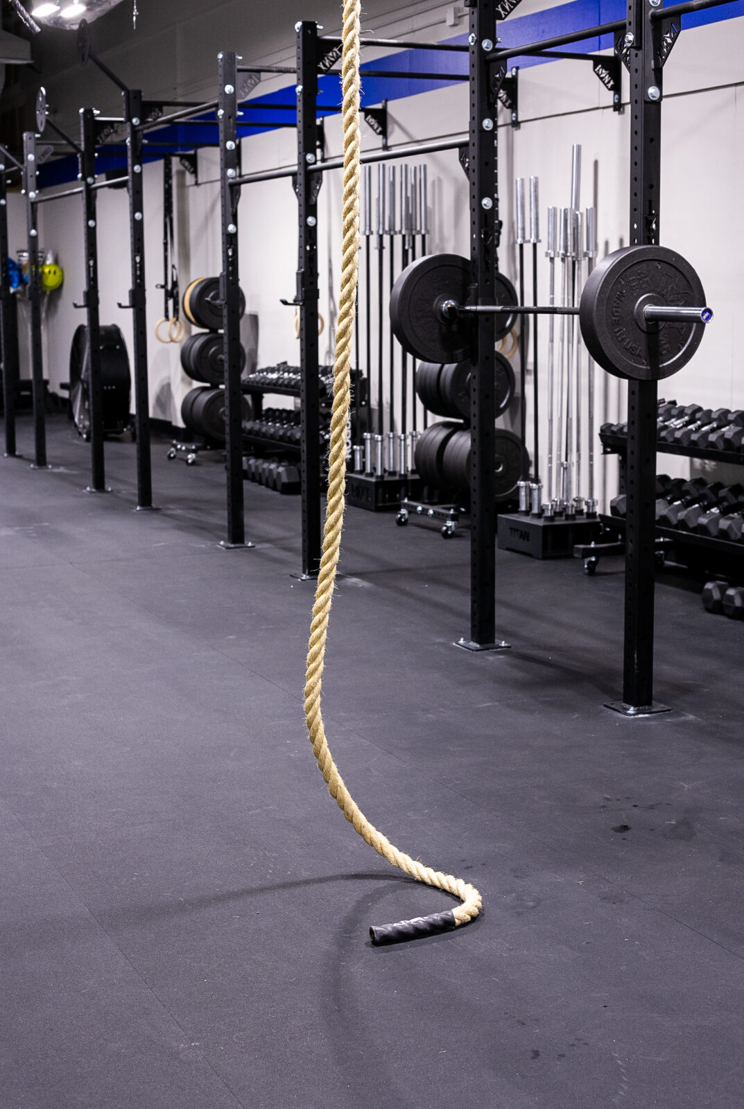 A climbing rope in the middle of a fitness gym.