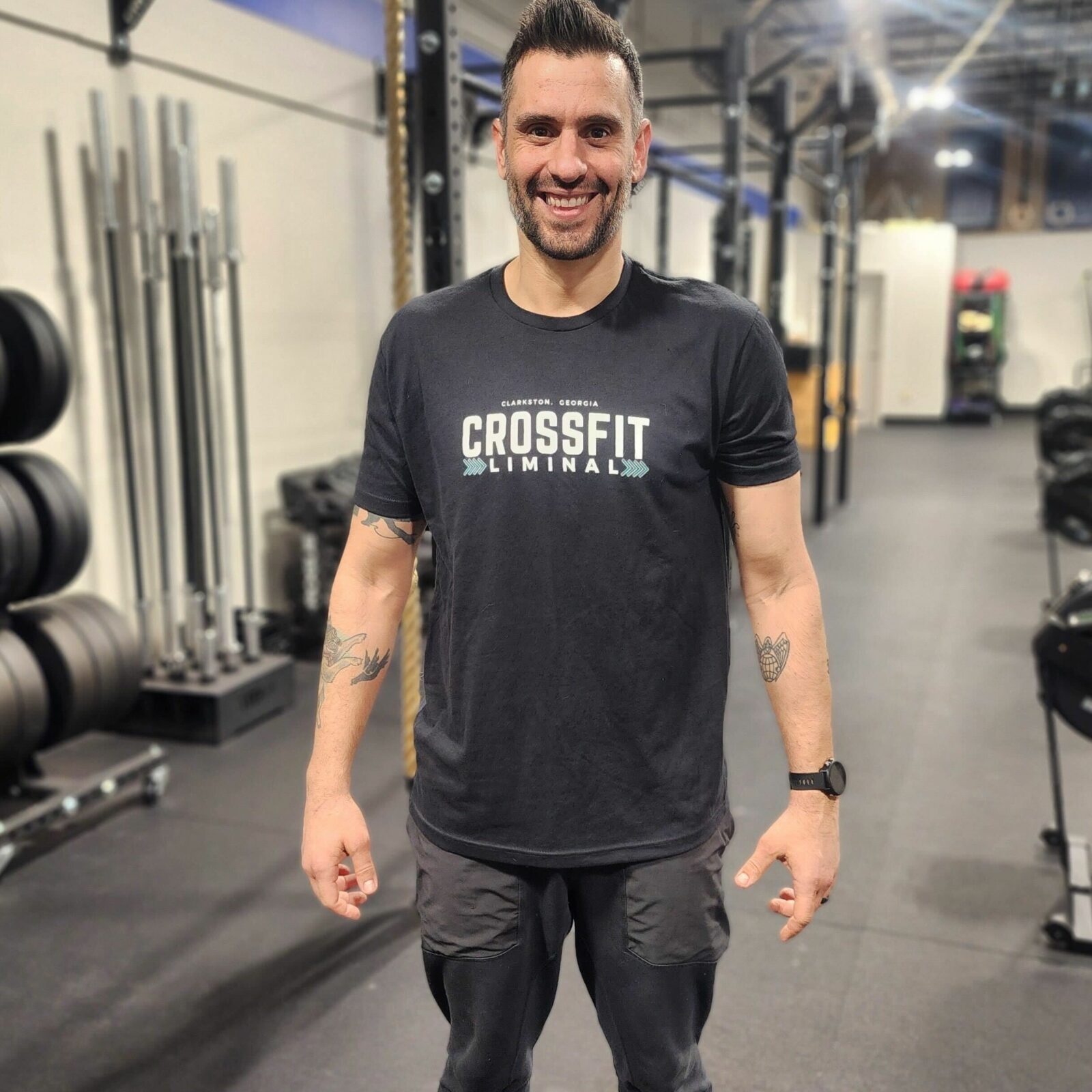 Member of board of directors posing for photograph, wearing CrossFit Liminal t-shirt.