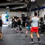 Several people lifting weights in a fitness gym.