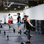 Several people in a fitness gym jumping rope.